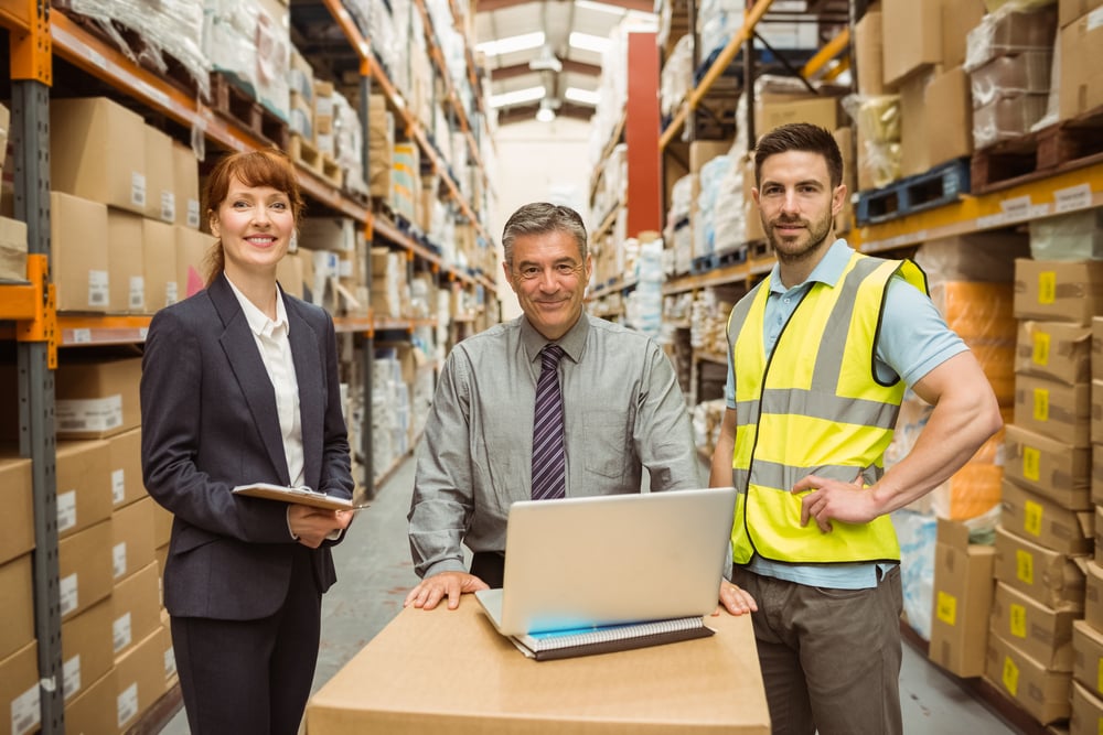 Smiling warehouse team working together on laptop in a large warehouse-Dec-05-2023-07-28-24-9763-PM